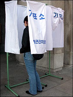 8일 낮 연세대 중앙도서관 앞에 설치된 투표소에서 파병찬반투표에 참여하고 있는 대학생. 